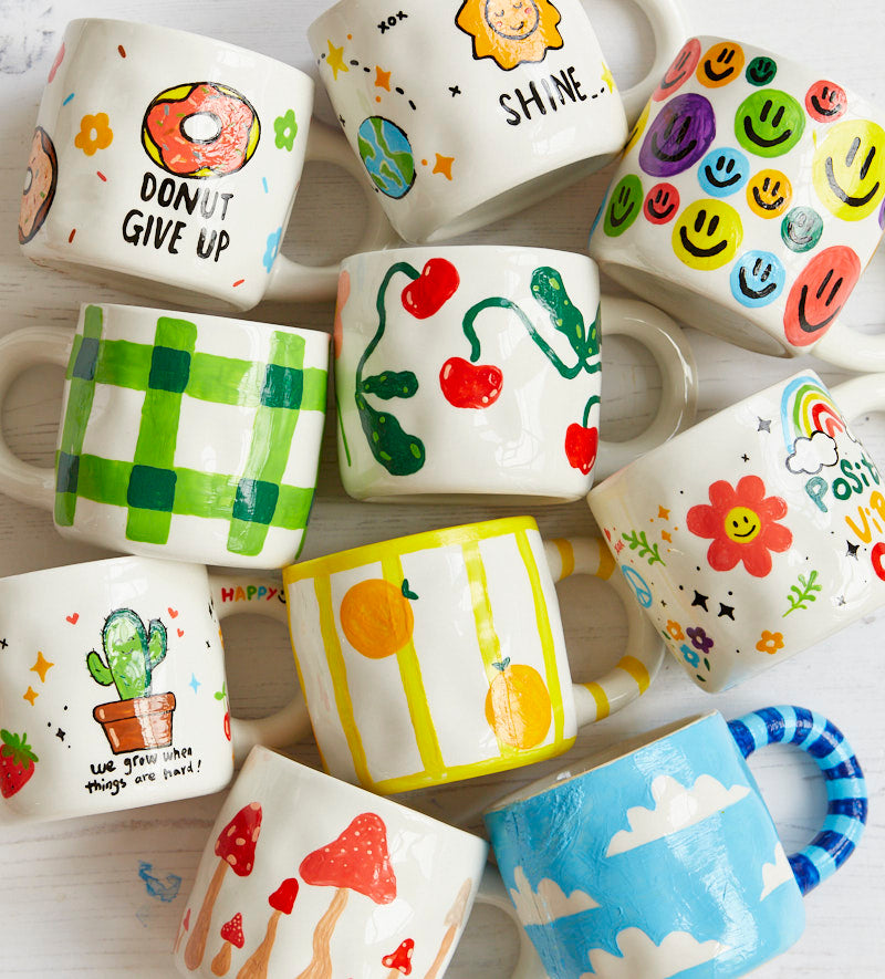 A tableful of hand-painted Pott'd mugs, every one different